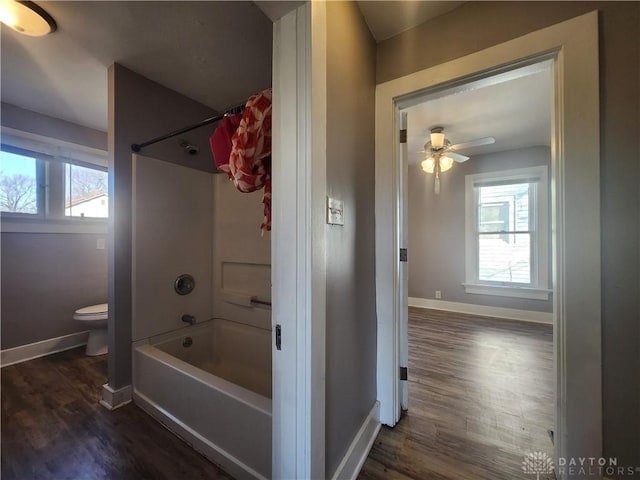 bathroom with hardwood / wood-style floors, shower / bath combination, toilet, and ceiling fan