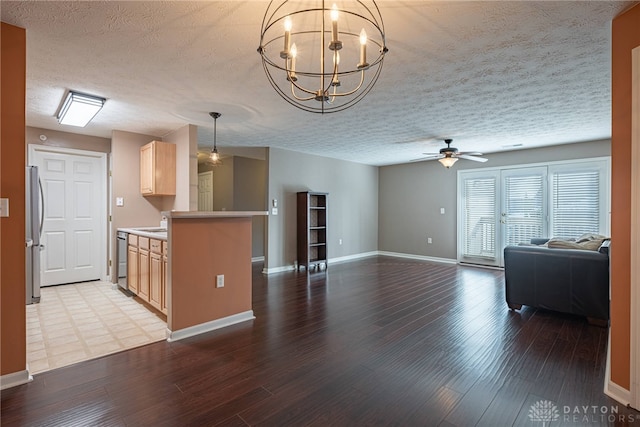 kitchen with appliances with stainless steel finishes, light wood-type flooring, ceiling fan with notable chandelier, a textured ceiling, and light brown cabinets