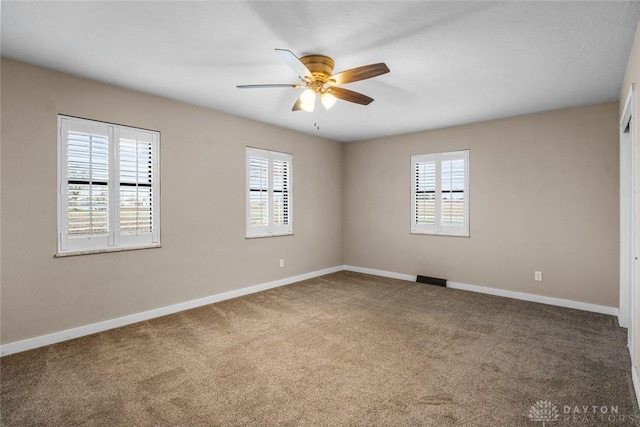 unfurnished room with carpet, baseboards, and a wealth of natural light