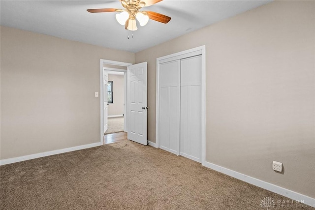 unfurnished bedroom featuring a closet, carpet flooring, a ceiling fan, and baseboards