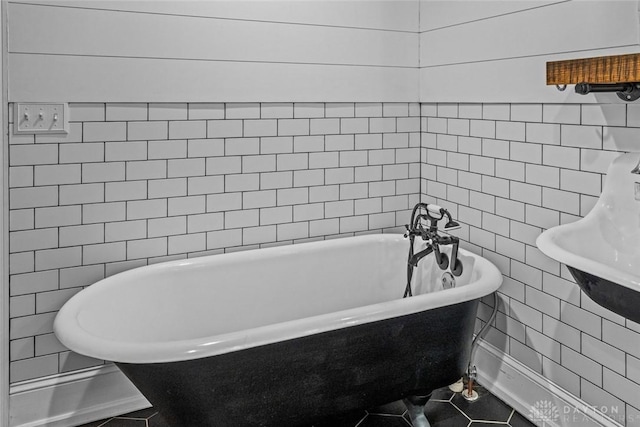 bathroom featuring tile patterned flooring, a soaking tub, and tile walls