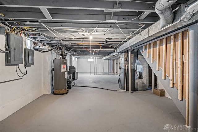 unfinished below grade area featuring water heater, stairs, and electric panel