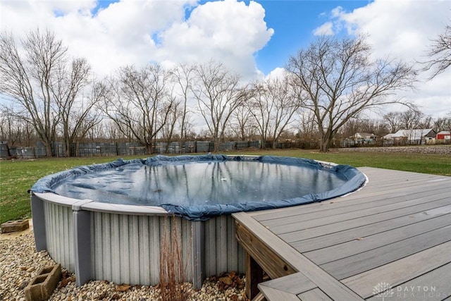 view of pool featuring a lawn and a wooden deck