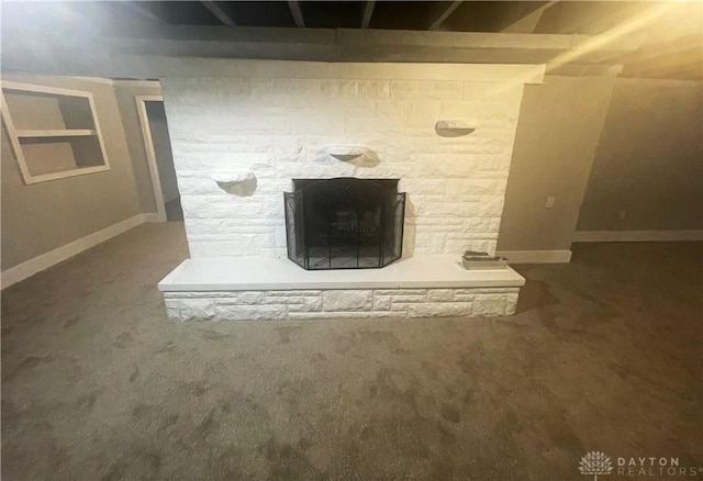 interior details featuring carpet, baseboards, and a stone fireplace