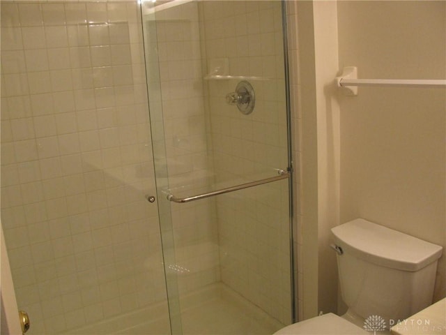 bathroom featuring an enclosed shower and toilet