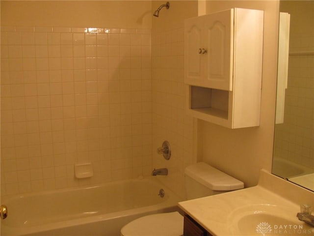 full bathroom with vanity, tiled shower / bath combo, and toilet