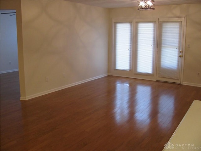 unfurnished room with dark wood-type flooring