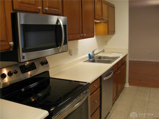 kitchen with light tile patterned flooring, appliances with stainless steel finishes, and sink