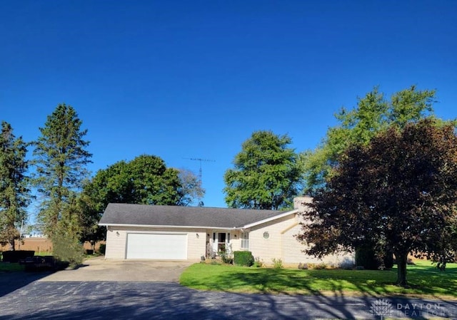 single story home featuring a garage and a front lawn