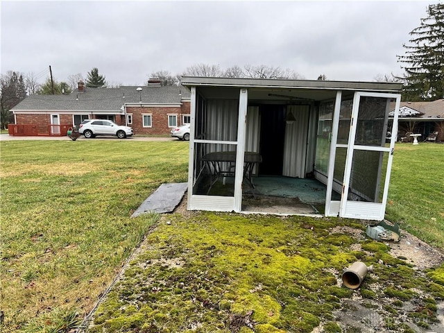 back of house featuring a yard and a sunroom