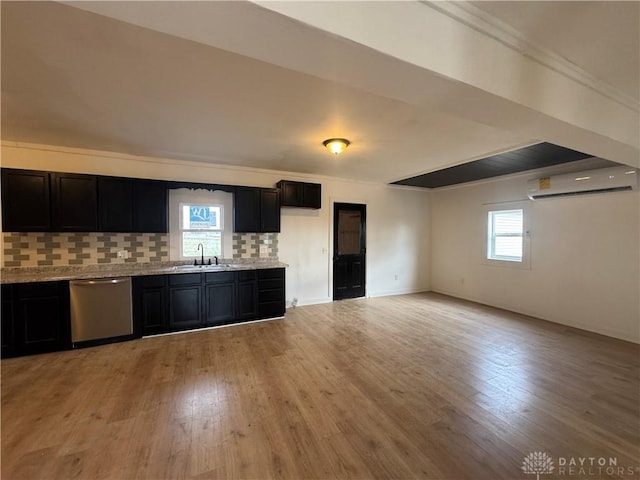 kitchen featuring stainless steel dishwasher, tasteful backsplash, light hardwood / wood-style flooring, and a wall mounted AC