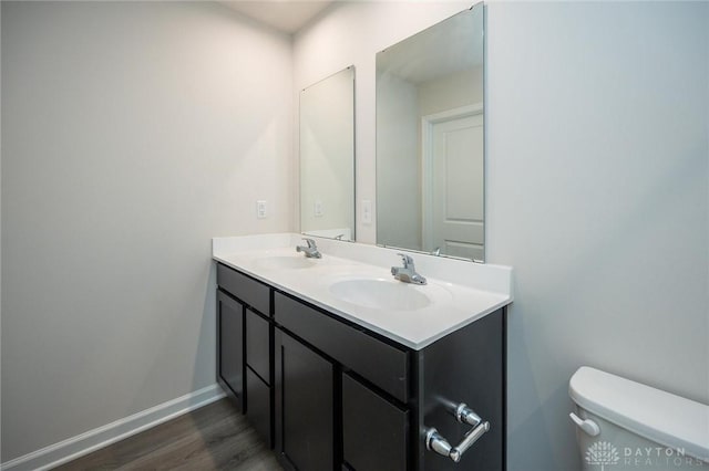 bathroom with vanity, wood-type flooring, and toilet