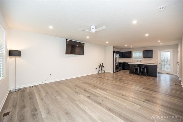 unfurnished living room featuring ceiling fan and wood-type flooring