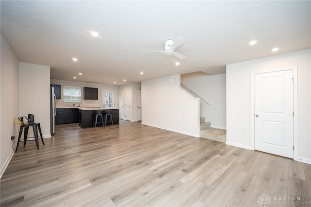 living room featuring ceiling fan and light hardwood / wood-style flooring