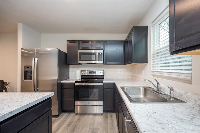 kitchen featuring a wealth of natural light, light hardwood / wood-style flooring, sink, and appliances with stainless steel finishes