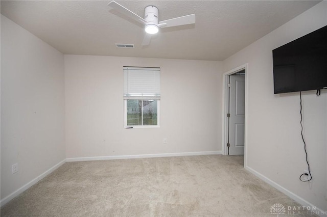 carpeted spare room featuring ceiling fan