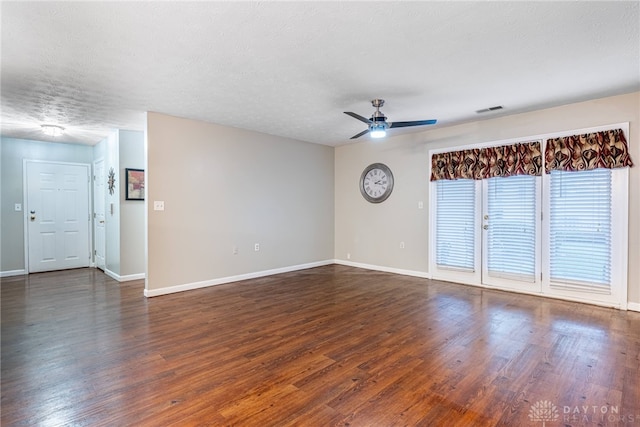 empty room featuring dark hardwood / wood-style floors, ceiling fan, and a textured ceiling