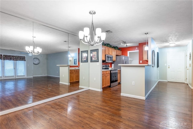 kitchen featuring pendant lighting, dark hardwood / wood-style floors, a textured ceiling, appliances with stainless steel finishes, and kitchen peninsula