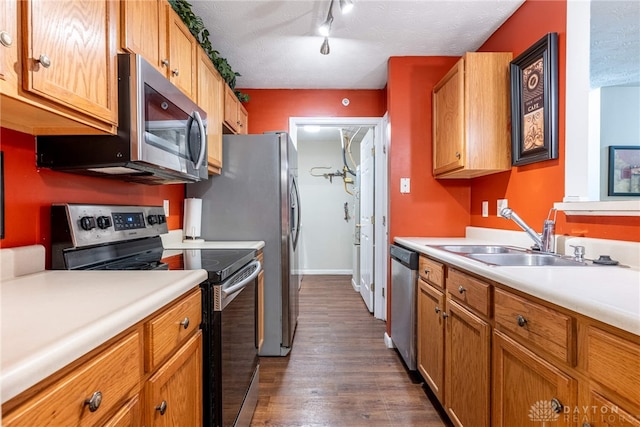 kitchen with dark hardwood / wood-style flooring, a textured ceiling, stainless steel appliances, and sink