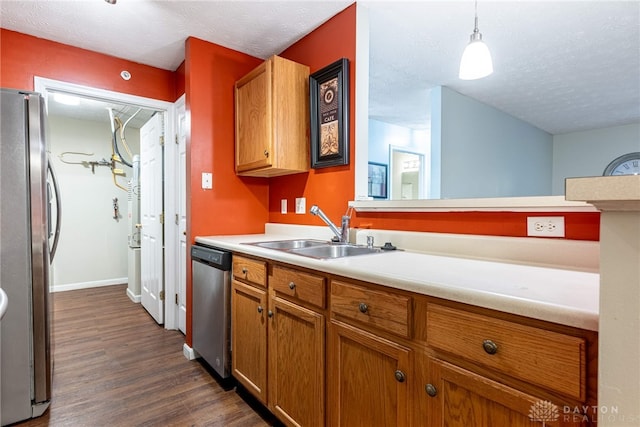 kitchen featuring hanging light fixtures, sink, dark hardwood / wood-style floors, a textured ceiling, and appliances with stainless steel finishes