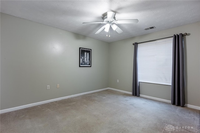 unfurnished room featuring a textured ceiling, light colored carpet, and ceiling fan