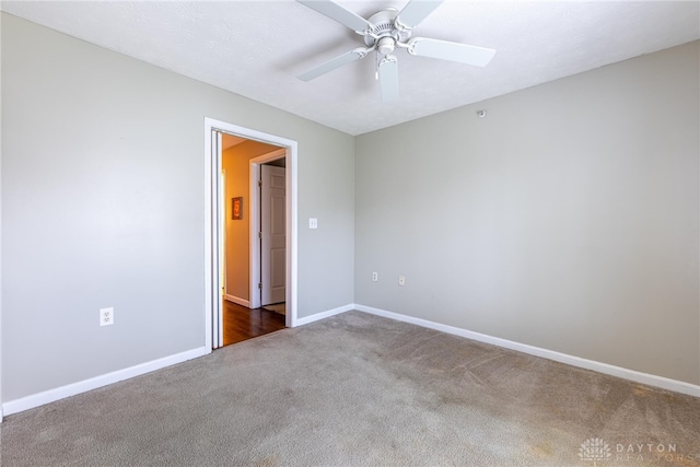 empty room with dark colored carpet and ceiling fan