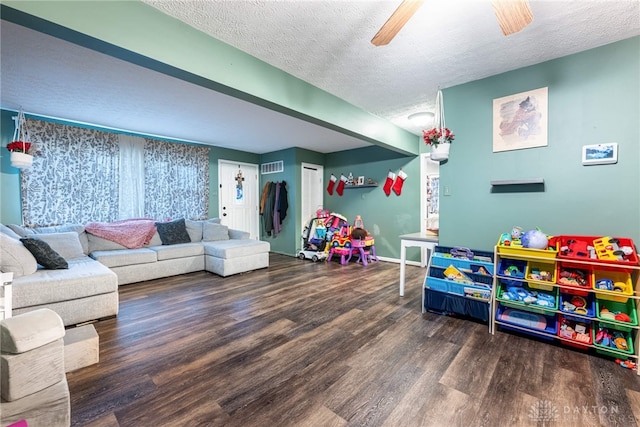 recreation room with dark hardwood / wood-style floors, ceiling fan, and a textured ceiling