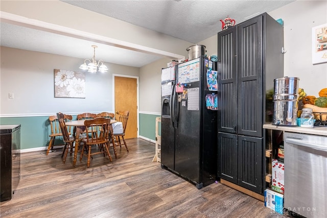 kitchen with black fridge with ice dispenser, a textured ceiling, dark wood-type flooring, pendant lighting, and a chandelier