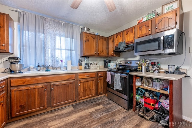 kitchen featuring a textured ceiling, dark hardwood / wood-style floors, sink, and stainless steel appliances