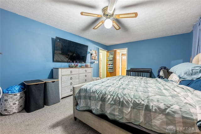 carpeted bedroom featuring ceiling fan and a textured ceiling