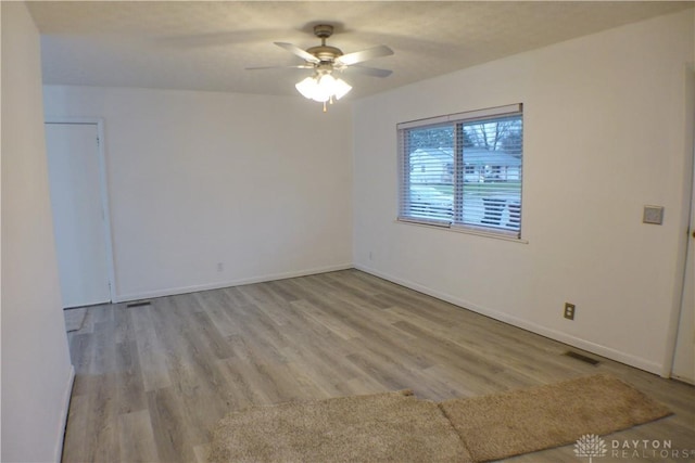 empty room with ceiling fan and light hardwood / wood-style flooring