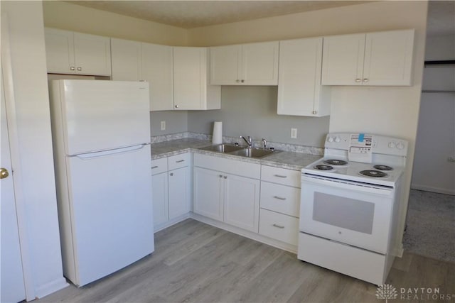 kitchen with white cabinets, white appliances, light hardwood / wood-style floors, and sink