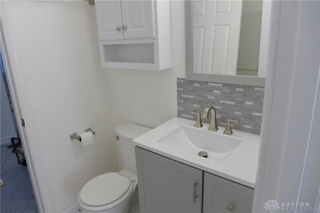 bathroom with tasteful backsplash, vanity, and toilet