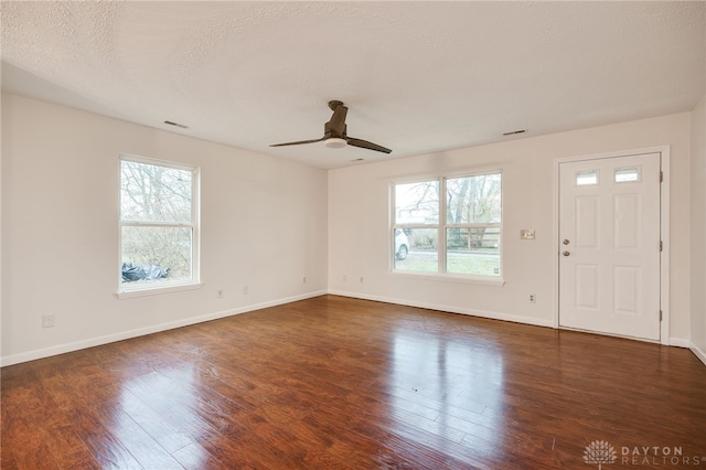 interior space with a textured ceiling, dark hardwood / wood-style floors, and ceiling fan