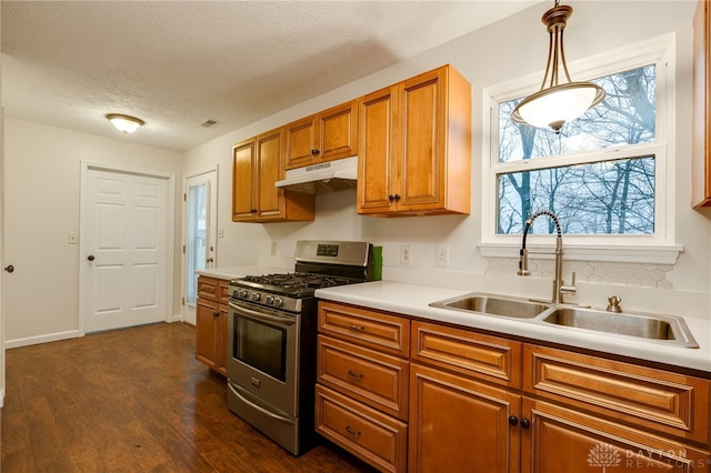 kitchen featuring pendant lighting, stainless steel range with gas cooktop, sink, a textured ceiling, and dark hardwood / wood-style flooring