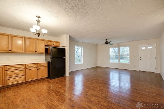 kitchen featuring dark hardwood / wood-style flooring, a wealth of natural light, and black refrigerator