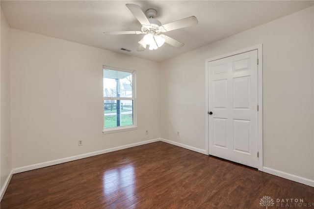 unfurnished room featuring ceiling fan, dark hardwood / wood-style flooring, and a textured ceiling