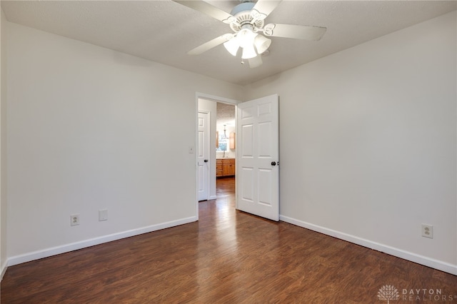 empty room with ceiling fan and dark hardwood / wood-style flooring