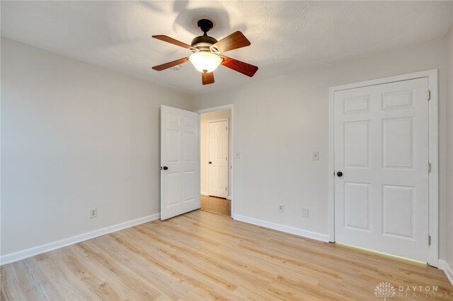 unfurnished bedroom with ceiling fan, light hardwood / wood-style flooring, and a textured ceiling