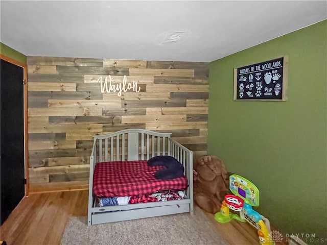 bedroom featuring wood-type flooring and wooden walls