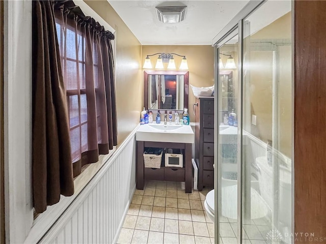 bathroom featuring tile patterned flooring, vanity, toilet, and walk in shower