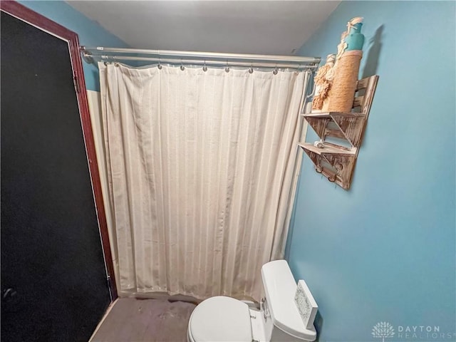 bathroom featuring curtained shower and toilet