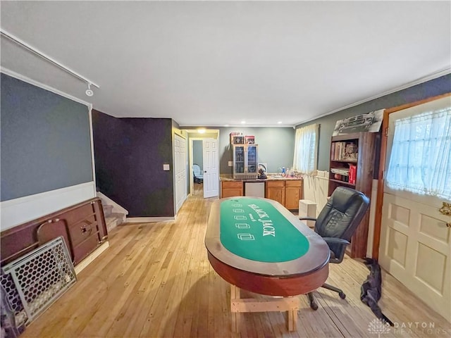 game room with light hardwood / wood-style floors and crown molding