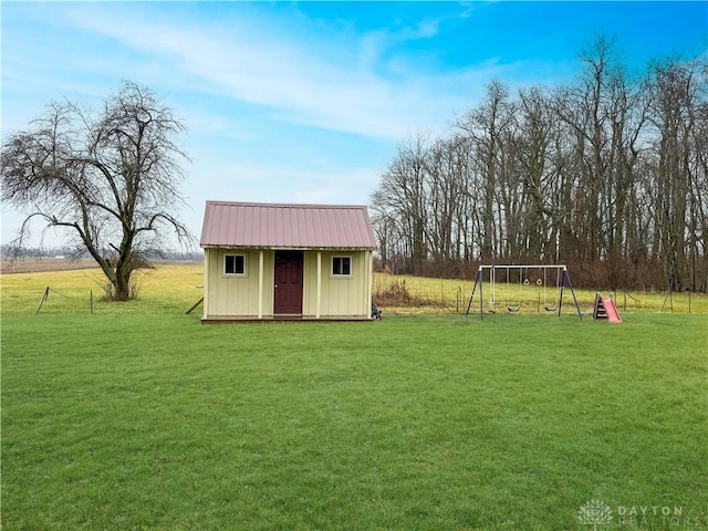 view of outdoor structure featuring a playground, a yard, and a rural view