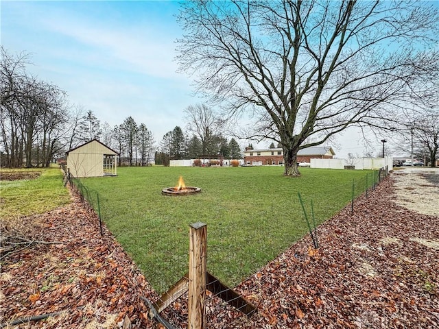 view of yard with an outdoor structure and an outdoor fire pit