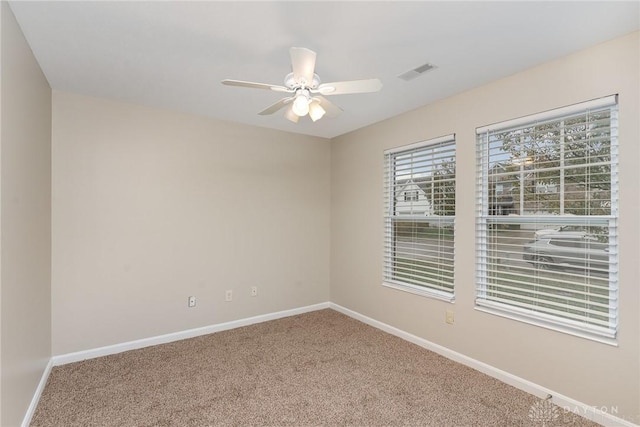 empty room featuring ceiling fan and carpet