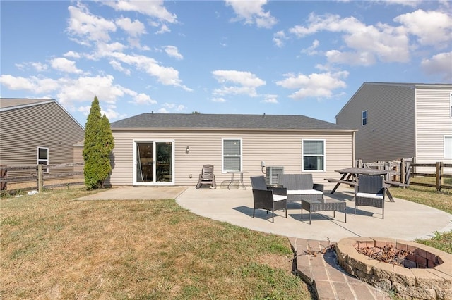 rear view of house with a lawn, a patio area, and an outdoor living space with a fire pit