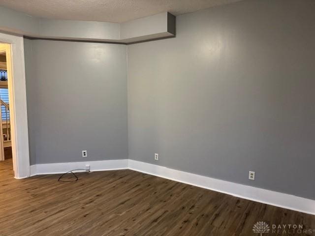 spare room featuring hardwood / wood-style floors and a textured ceiling