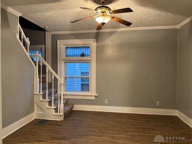 interior space featuring a textured ceiling, dark hardwood / wood-style floors, ceiling fan, and crown molding