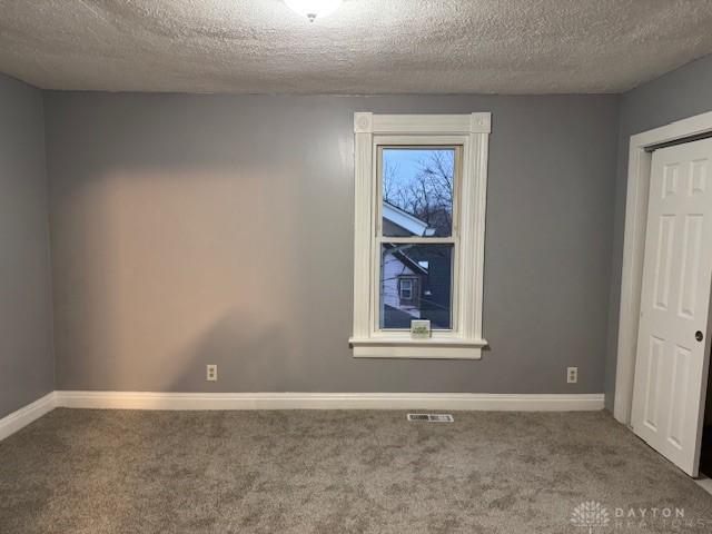 unfurnished bedroom featuring carpet flooring and a textured ceiling